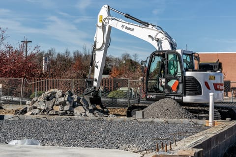 Bobcat E145 Digging Rocks In A Tight Area Of A Construction Site