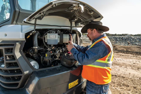 Operator checks the air filter on a Bobcat E50 compact excavator