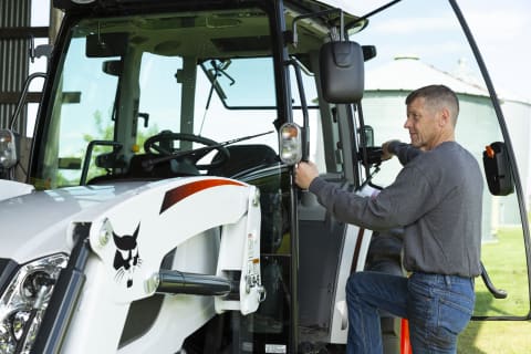 An Operator Getting Into a Bobcat CT5558 Compact Tractor