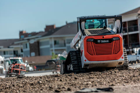 Operator Looking Out Rear View Window In Compact Track Loader