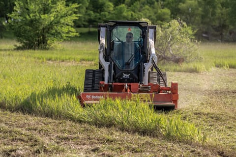 Grounds Maintenance Professional Using Compact Track Loader With Flail Cutter