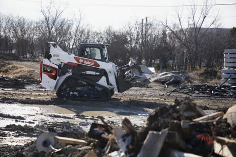 R-Series Compact Track Loader Moving Material With Industrial Grapple Attachment