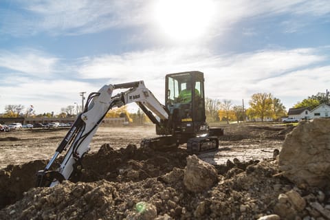 Bobcat E35 R-Series compact excavator digging in a field