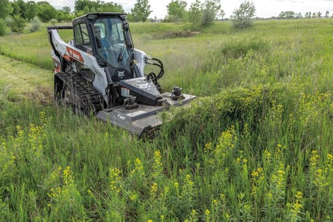 Operator Uses a Bobcat T76 Compact Track Loader and Brushcat Attachment to Mow Down Overgrown Grass