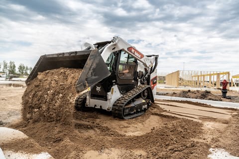 A Bobcat T64 With Bucket Attachment Dumps Dirt 