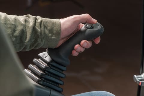 Operator using joystick controls in a Bobcat compact (mini) excavator