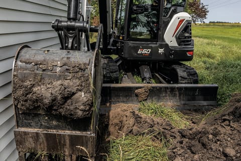 A Bobcat E60 compact excavator working in a confined space