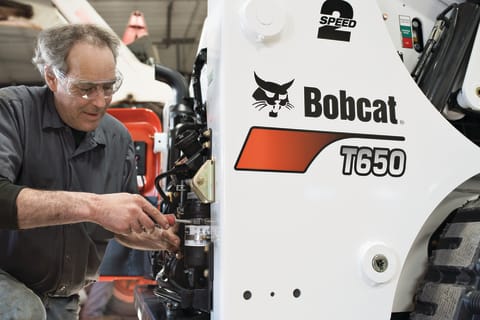 Service Technician Working On A Bobcat T650 Compact Track Loader