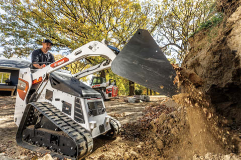 Un operador descarga tierra con una minicargadora de orugas MT100
