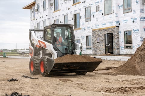 Bobcat S76 Skid-Steer Loader Hauling Dirt On A Construction Site 