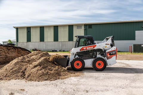 Bobcat skid-steer loader moving silage