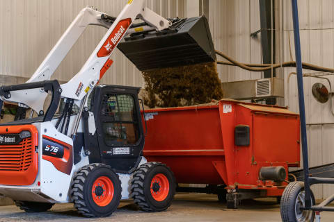 Skid-Steer Loader Dumping Material