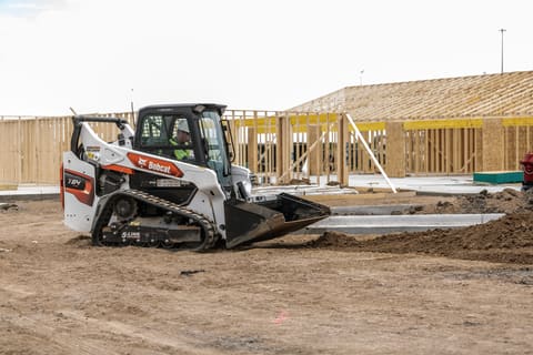 Bobcat T64 compact track loader on a construction jobsite grading dirt.