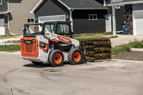 A Bobcat Skid-Steer Loader Carries a Large Pallet of Sod