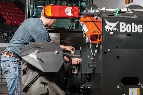 A Man Performs Maintenance on a Bobcat TL519 Telehandler