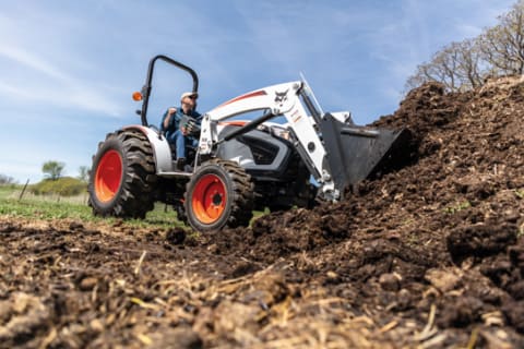 Operator Using A Bobcat CT4050 Compact Tractor With Front-End Loader To Move Mulch