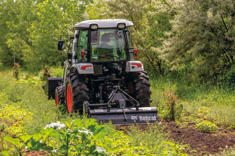 Bobcat Compact Tractor Using Rear PTO With 3-Point Tiller On Acreage