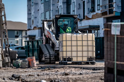 R-Series Compact Track Loader Lifting Heavy Material With Pallet Fork On Construction Site