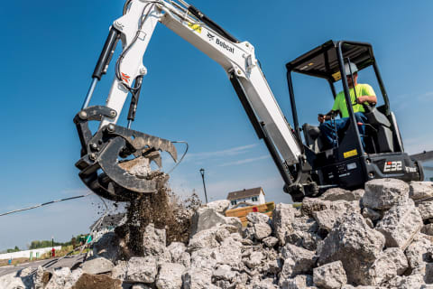 An R-Series E32 excavator moves demolished concrete on a jobsite