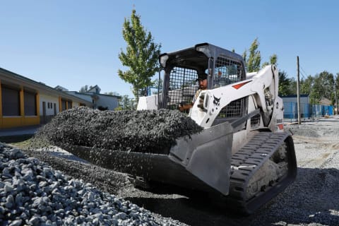 La cargadora compacta de orugas Bobcat T650 mueve grava en una obra de construcción.