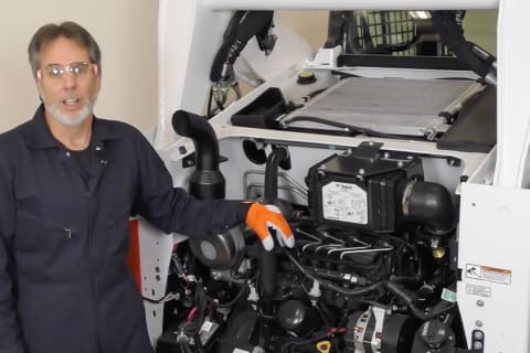 A Bobcat technician demonstrates how to change an air filter on a loader.