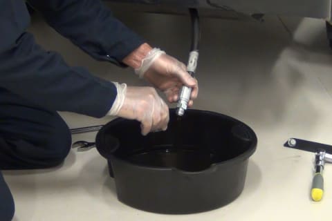 A Bobcat technician demonstrates how to change a oil on a Bobcat engine.