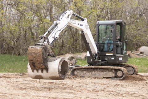 Operator In Bobcat Excavator Working On Jobsite