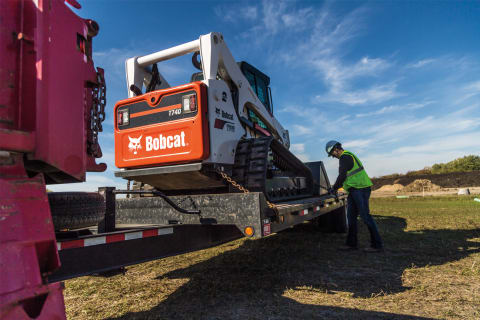 El operador encadena el Bobcat T740 al remolque