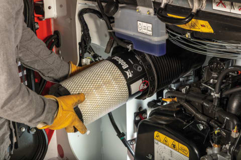 Owner Replacing Air Filter Inside R-Series Compact Loader