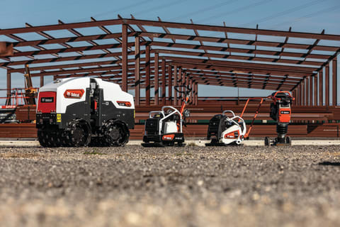 Four Bobcat Light Compaction Products Lined Up on a Jobsite: a Trench Roller, Reversible Plate Compactor, Forward Plate Compactor and Rammer