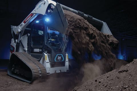 A Bobcat Electric Compact Track Loader Dumping Dirt From a Bucket 