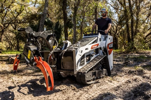 Bobcat MT100 Mini Track Loader with Log Grapple Attachment Working in Wooded Area