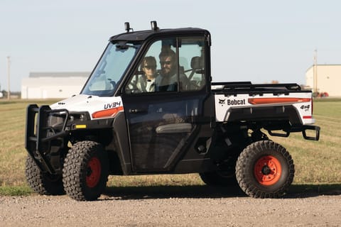 Operator uses a Bobcat UTV to travel down a road