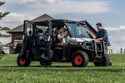 Pasajeros saliendo de una Bobcat UV34XL estacionada