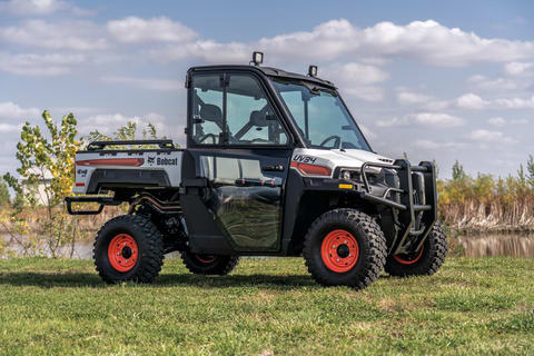 Vehículo utilitario Bobcat estacionado en el campo.