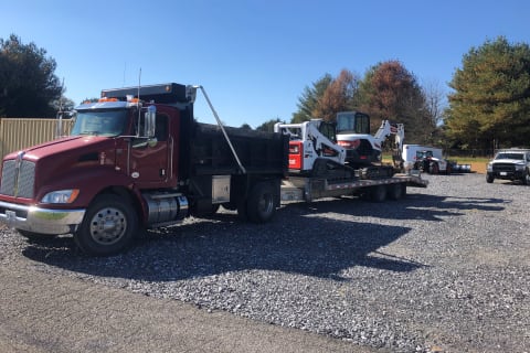 Wilson Fence’s Bobcat loader and Bobcat excavator on a semi-truck bed. 