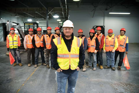 Image of Dom Del Monaco with his Red Rock Industries crew in safety vests and hard hats.