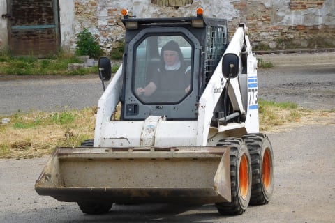 Zusters bedienen Bobcat-lader om nieuwe thuis te renoveren