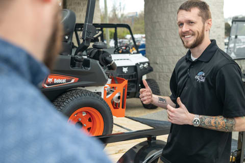 A Bobcat Dealer Employee Talks With a Customer on the Grounds of a Bobcat Dealership