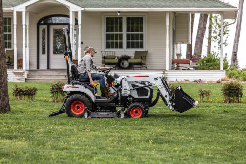 A Homeowner Mows the Front Yard With a Bobcat Sub-Compact Tractor