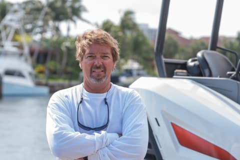 Dave Wayt, owner of A and D Construction, smiling next to his Bobcat E35 mini excavator.