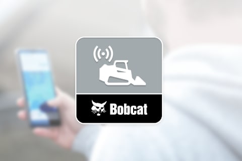 A man using the Bobcat Machine IQ App to control his E50z Mini Excavator.