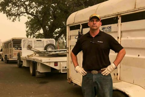 Retired U.S. Marine, Tucker Zimmerman, sales specialist at Bobcat of Redding standing with truck and trailer used to evacuate animals when the Carr Fire threatened the community