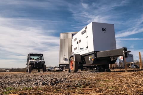 Bobcat Portable Power PG50 Generator Next to a Utility Vehicle in Field