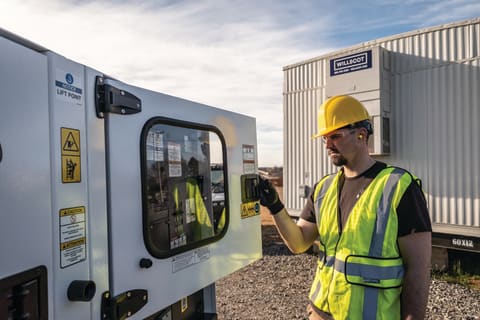 An Operator Opens the Door to the Control Panel on a Bobcat PG50 Portable Generator