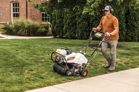 An Operator Uses the Bobcat AE19 Aerator on a Section of Grass