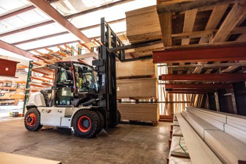 A Bobcat D70S-9 Forklift Grabs a Stack of Wood From a Shelf at a Lumberyard