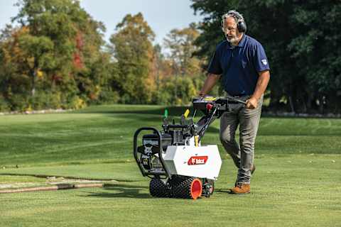 A Man Steers the Bobcat SC18 Sod Cutter on a Golf Course Putting Green