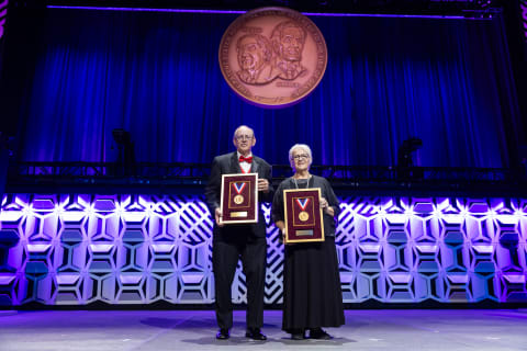 Keller family representatives hold the National Inventors Hall of Fame awards recognizing Louis and Cyril Keller.