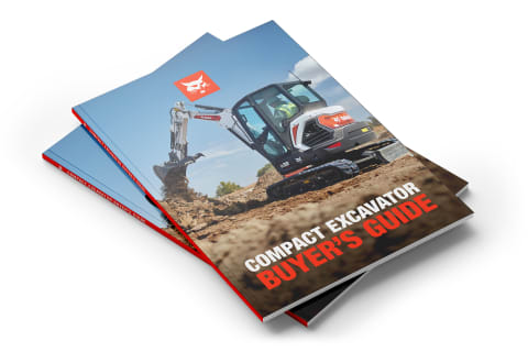 A pair of Bobcat Compact Excavator Buyer’s Guide books rest on a gray surface.